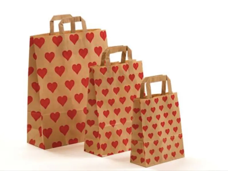 Papierhenkeltaschen mit roten Herzen bedruckt